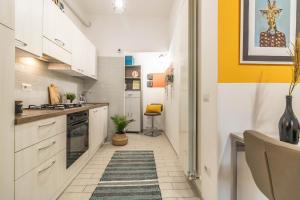 a kitchen with white cabinets and a rug on the floor at Residenza Il Torrione in Iesi