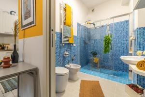 a bathroom with a toilet and a shower with blue tiles at Residenza Il Torrione in Iesi