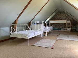 ein Dachzimmer mit drei Betten und Teppichen in der Unterkunft MEZKOLE - Maison de vacances familiale à Plouguerneau 10 personnes, jardin, proche plages in Plouguerneau