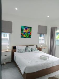 a bedroom with a bed with a painting on the wall at Tranquility in Bangrak Beach