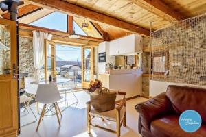 タロワールにあるLe Grenier 4 - Mazot Savoyardのソファとテーブルのあるキッチンとリビングルーム