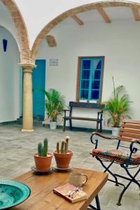 a living room with a table and a bench and cactus at El Conventillo de San Roque in San Roque