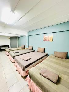 fila de camas en una habitación con paredes azules en Patong Adventure Hostel, en Patong Beach