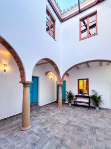 a courtyard with arches and a bench in a building at El Conventillo de San Roque in San Roque