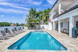 ein Swimmingpool im Hinterhof eines Hauses in der Unterkunft Waterfront Luxury Villa Heated Pool with Afternoon Sun Coral Key in Fort Lauderdale