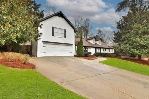 a white house with a garage and a driveway at Sandy Springs Retreatpoolhottubking Bed in Atlanta