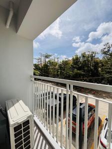 a balcony with a view of a car at Convenient City Hub with Relaxing Interior in Mandurriao