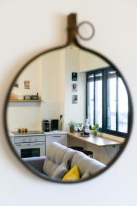 uno specchio che riflette un soggiorno con divano e tavolo di Beach Apartments TLV a Tel Aviv