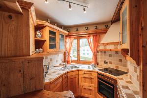 a kitchen with wooden cabinets and a sink and a window at LAAX Homes - Casa Allgäu in Laax-Murschetg