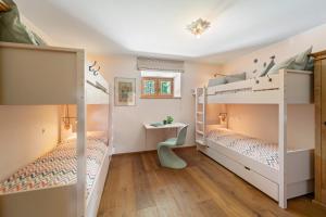 two bunk beds in a room with a desk at Abitaziun Acla Albanatscha - Silvaplana in Silvaplana