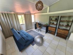 a living room with a blue couch and a table at Casa aconchegante em área verde in Niterói