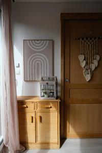 a room with a wooden cabinet next to a door at Le Nid Bohème in Gisay