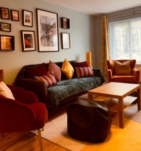 a living room with a couch and a table at Lovely 2 bedroom house in Bath with private parking garden WiFi & easy access to city centre in Bath