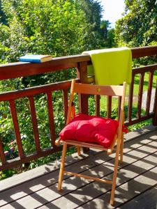 a green chair with a red pillow sitting on a deck at Villino Lavarello in Verbania