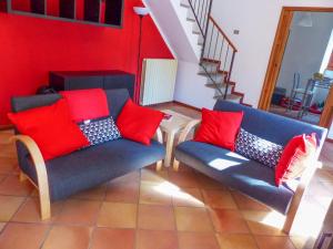 a living room with two blue chairs and red pillows at Villino Lavarello in Verbania