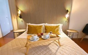 a bed with a tray of food and two cups of coffee at Le Clarisse Pigna Apartment in Rome