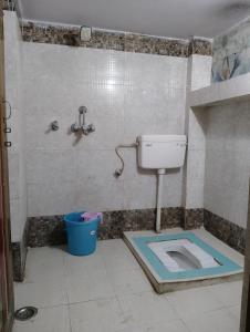 a bathroom with a toilet and a bucket in it at Shreeji niwas in Varanasi