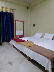 two large beds in a room with a mirror at Shreeji niwas in Varanasi