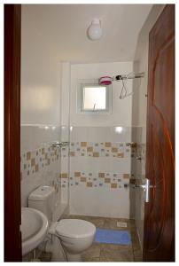 un bagno con un water e un lavandino di K&K Stays a Nakuru Altre 13 foto