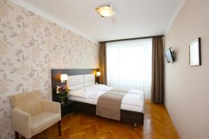 a hotel room with a large bed and a large window at Medos Hotel in Budapest