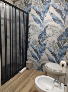 Quartu Sant'ElenaにあるJungle Loftの白いトイレと青と白の壁紙のあるバスルーム +11枚の写真
