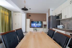 a dining room with a wooden table and chairs at Apartament Miramare in Mamaia Nord