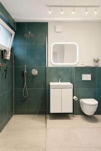 a bathroom with green walls and a toilet and a sink at Zimmer im besonderem Haus "Columbus" -FjordStay in Kiel