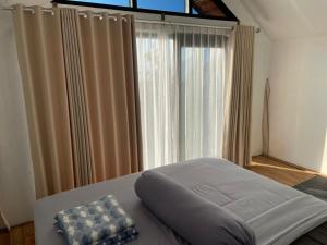 a bed in a room with a large window at Alengkong Bali Camp in Kubupenlokan