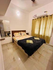 a bedroom with a bed with two towels on it at Rock Finch Holiday Homes - Malpe Beach in Udupi