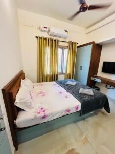 a bedroom with a bed with pink flowers on it at Rock Finch Holiday Homes - Malpe Beach in Udupi +54 photos
