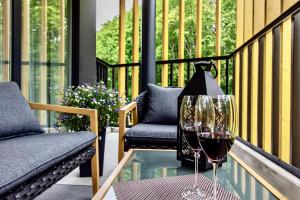 a glass of wine on a glass table on a balcony at Premium Seaside Escape with Forest View and Free Parking in Tallinn