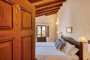 a bedroom with a bed and a wooden wall at Casa Cuesta del Reloj in Piedralaves +42 photos