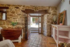 a large room with a stone wall and a doorway at Casa Cuesta del Reloj in Piedralaves