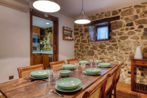 a dining room with a table and a stone wall at Casa Cuesta del Reloj in Piedralaves