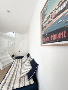 a bedroom with a bed with a poster on the wall at Jolie maison rénovée au port de Sainte Marine in Combrit +17 photos