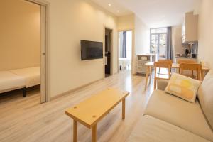 una sala de estar con un sofá y una mesa en Casa Felipa Plaza España, en Barcelona