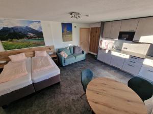 a bedroom with a bed and a couch and a table at Ferienhaus Mott in Lermoos