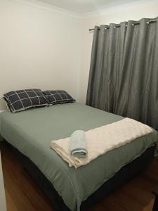 ジェラルトンにあるCharming West End Perfect for Workers & Touristsのベッド1台(毛布、枕付)