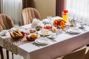 a white table with breakfast foods on it at Grand Nur Hotel in Tashkent