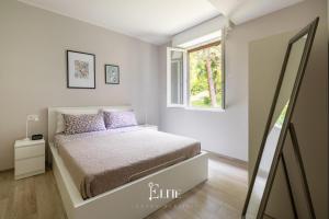 a small bedroom with a bed and a window at Lake Maggiore View Apt Ranco in Ranco