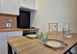 a table with plates and glasses on a kitchen counter at Les Loges du Beffroi - L'éclatant in Arras +7 photos