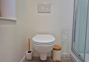a bathroom with a toilet and a glass shower at Les Loges du Beffroi - L'éclatant in Arras