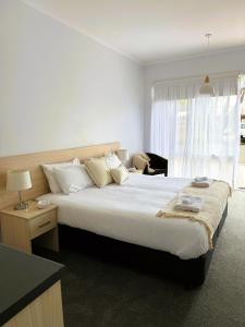 a hotel room with a large bed and a window at Kaloha Holiday Resort Phillip Island in Cowes +70 photos