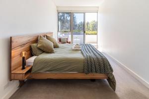 a bedroom with a large bed and a window at Bright & Spacious Penthouse by Parliament House in Barton