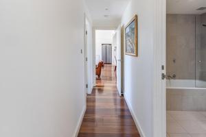 a hallway of a bathroom with a tub and a sink at Bright & Spacious Penthouse by Parliament House in Barton +41 photos