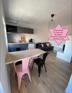ein Esszimmer und ein Wohnzimmer mit einem rosa Esstisch in der Unterkunft V3 Studio tout confort plein centre 5 min Golfech in Valence-dʼAgen