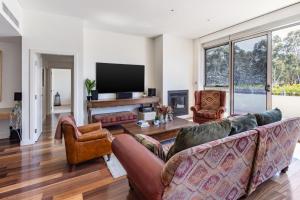 a living room with two couches and a flat screen tv at Bright & Spacious Penthouse by Parliament House in Barton