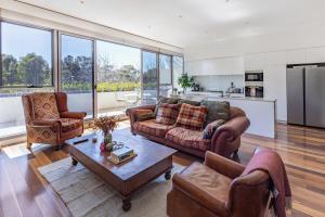 a living room with two couches and a table at Bright & Spacious Penthouse by Parliament House in Barton