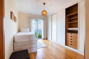 Ένα ή περισσότερα κρεβάτια σε δωμάτιο στο GuestReady - Madeiran paradise with ocean view