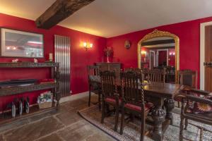 a dining room with red walls and a wooden table and chairs at Danby Lodge in Yorkley